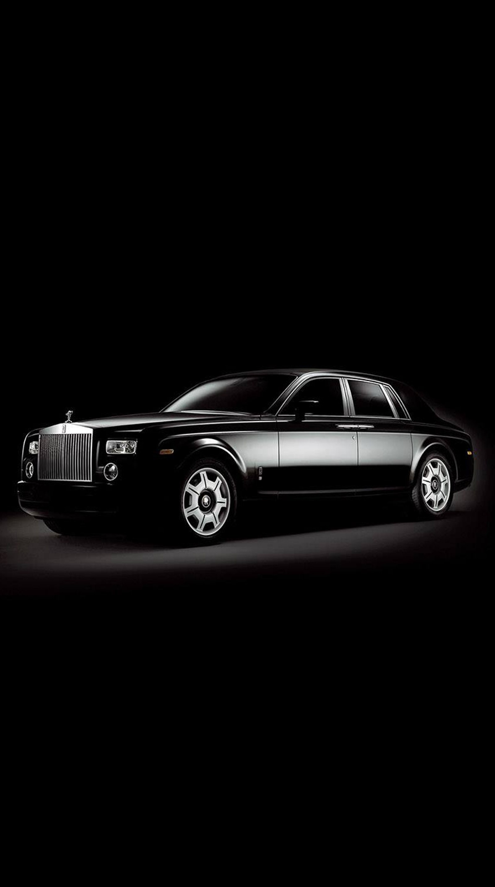 A close up of a black car in a dark room (car, rolls royce, royals, the)