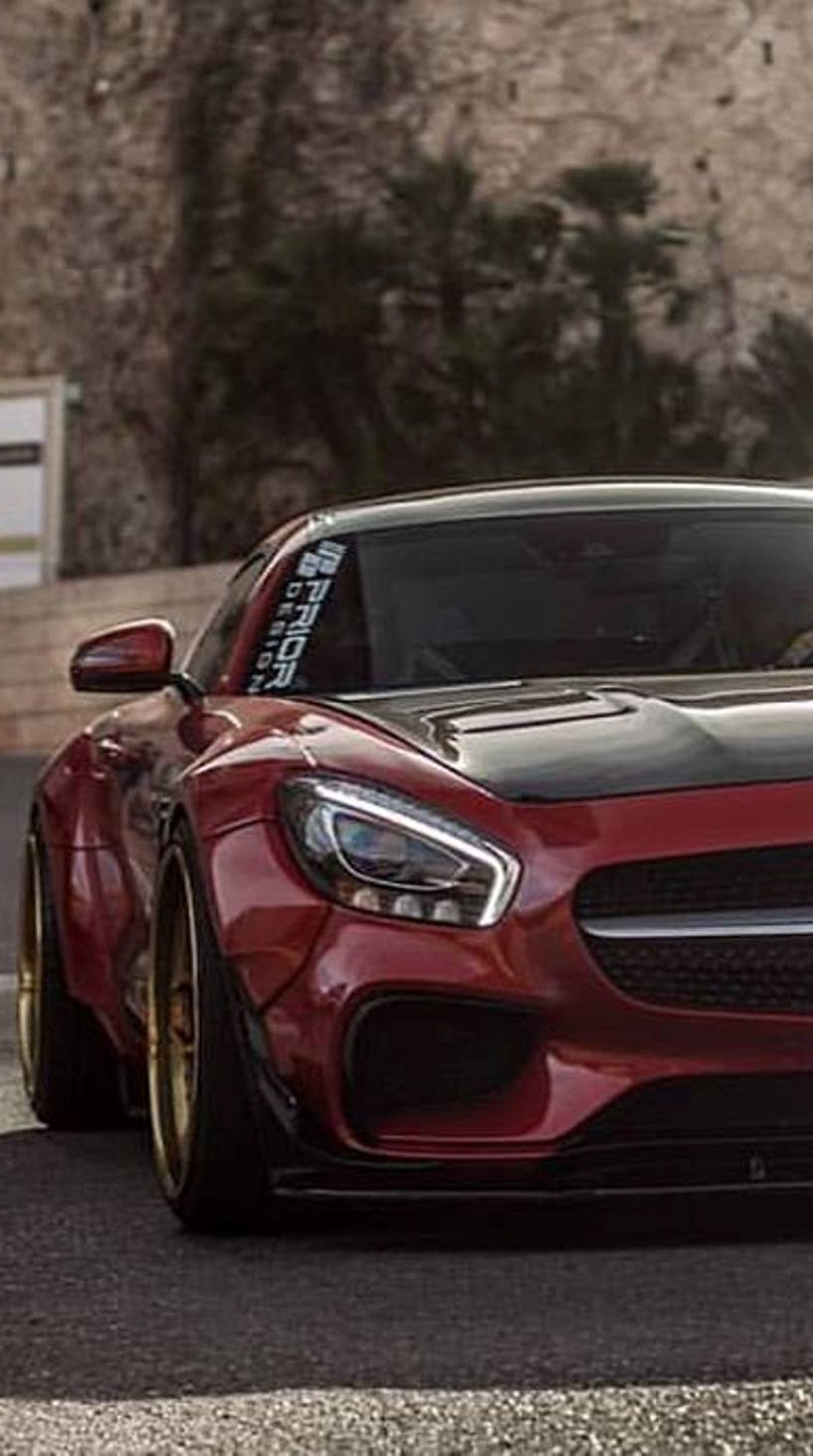 Un gros plan d'une voiture de sport rouge roulant sur une route (amg, voiture, mercedes, nouveau)