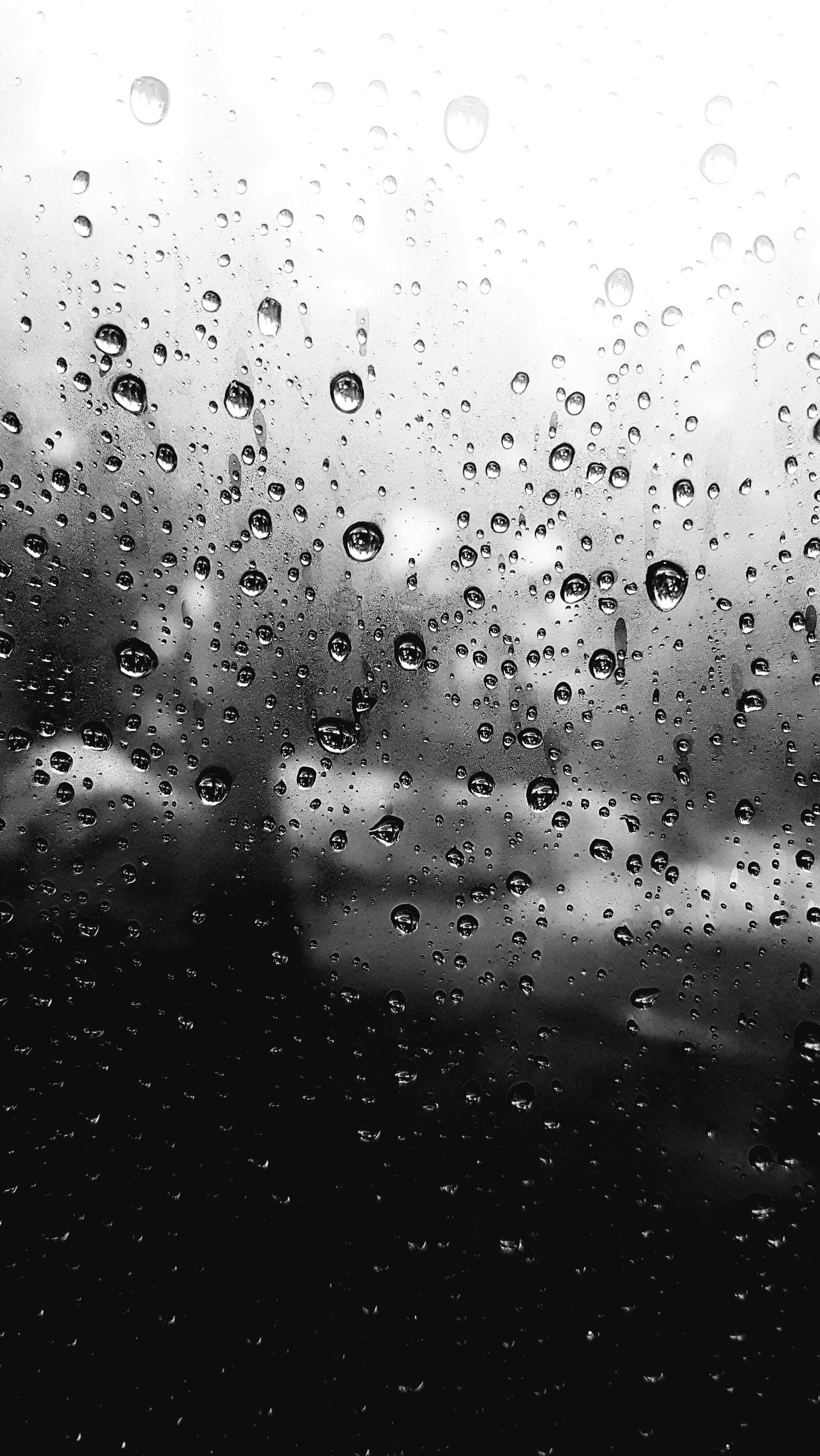 A close up of a rain covered window with rain drops (glass, rain, water)