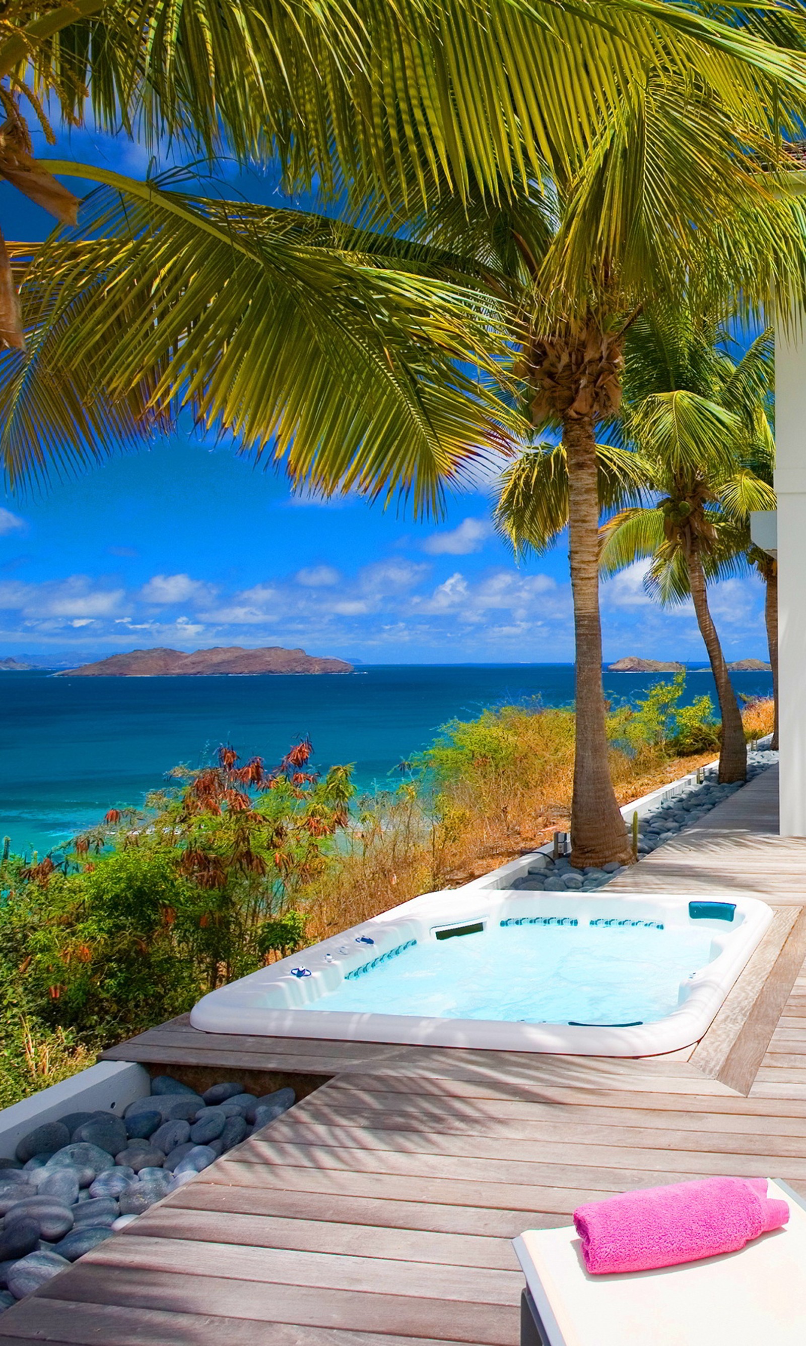 Auf dem deck eines hauses steht ein whirlpool mit blick auf den ozean (feiertag, luxus, schwimmbad, entspannung, resort)