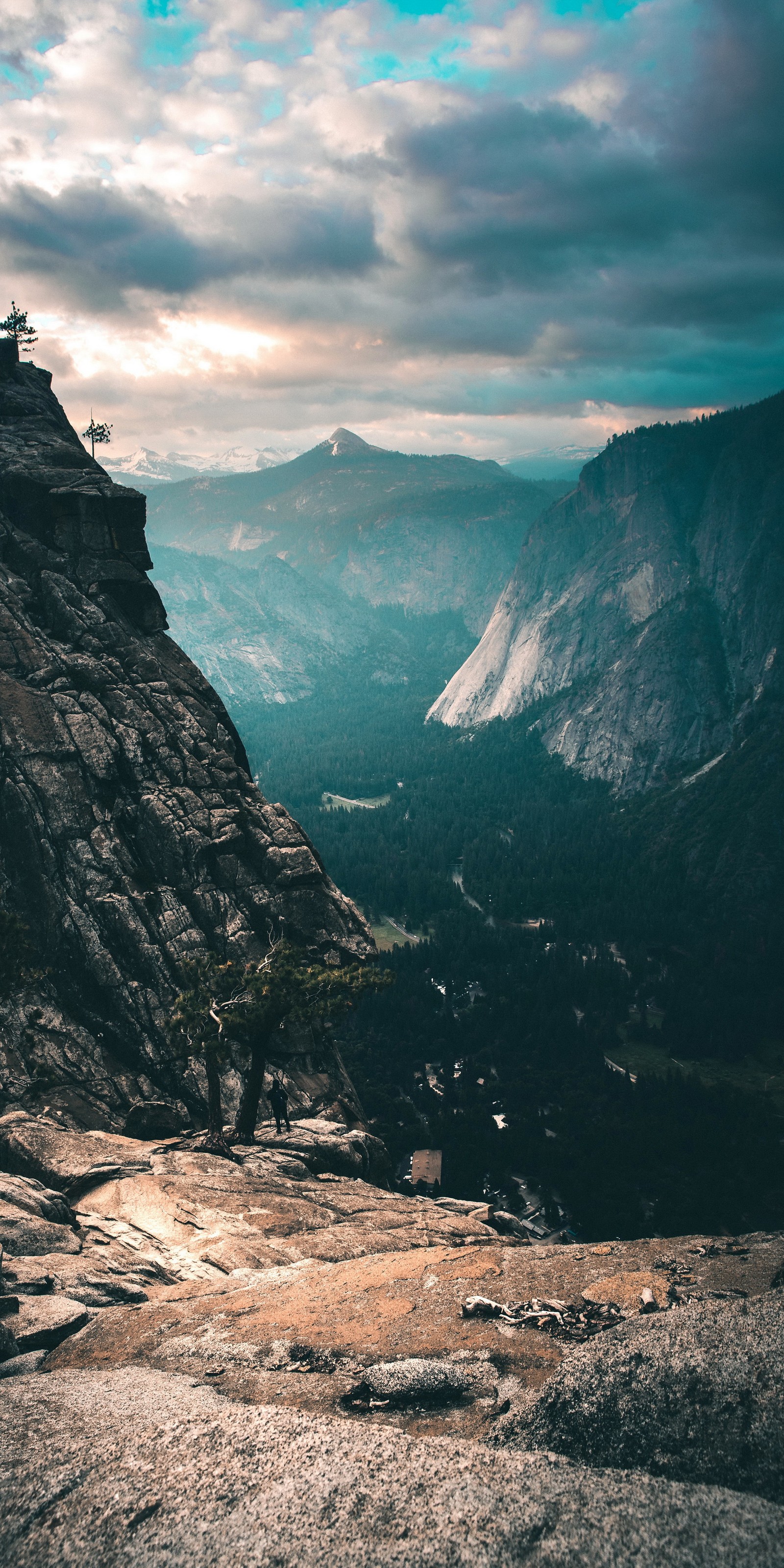 Une personne se tenant sur un rocher surplombant une vallée (nuage, montagne, atmosphère, monde, paysage naturel)