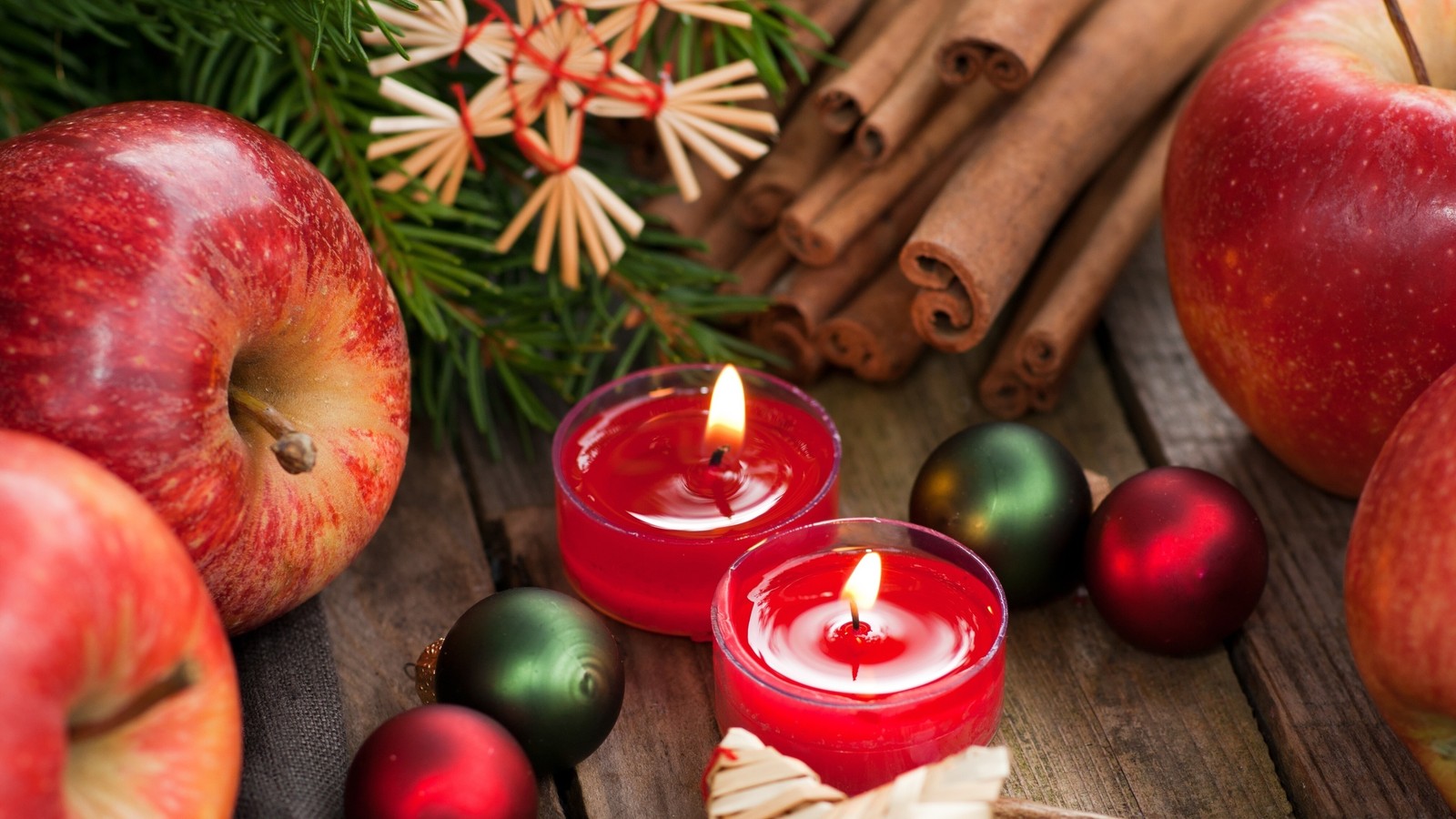 Des pommes et des bâtons de cannelle sont disposés autour d'une bougie sur une table (aliments naturels, pomme, fruit, nourriture, superaliment)