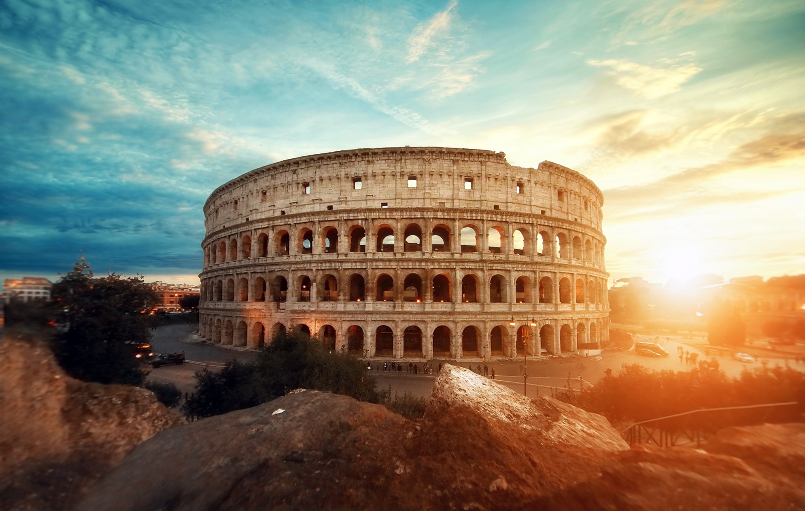 Eine nahaufnahme eines gebäudes mit einem himmelshintergrund und einem sonnenuntergang (kolosseum, amphitheater, historische struktur, rom, antike architektur)