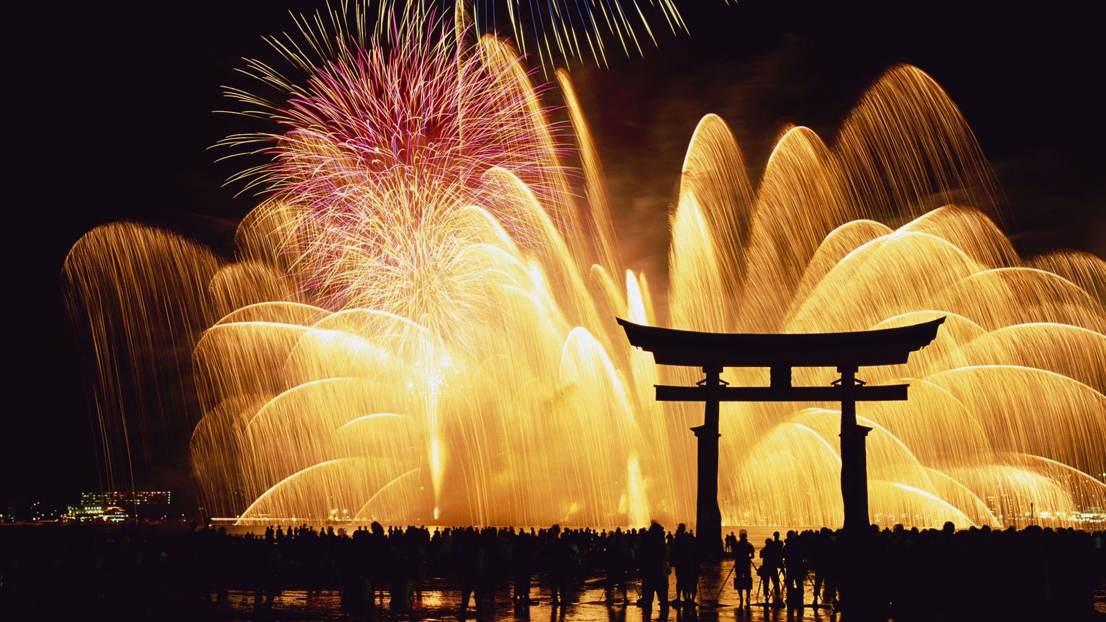 Des feux d'artifice s'illuminent dans le ciel au-dessus d'un portail torii (japon, réveillon, nouvel an, feux dartifice, événement)