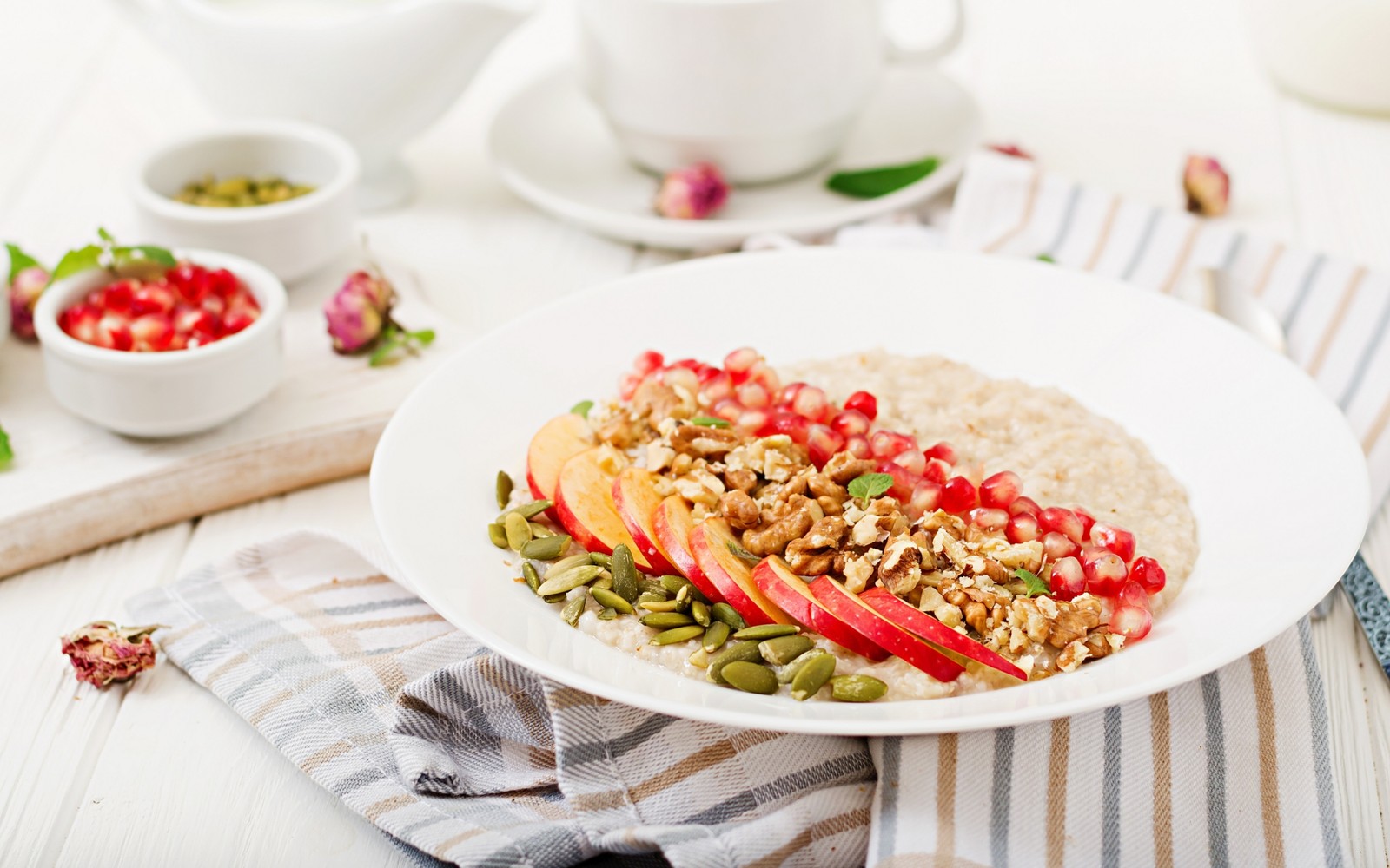 There is a bowl of oatmeal with apples and nuts on it (dish, vegetarian cuisine, breakfast, apples, fruit)