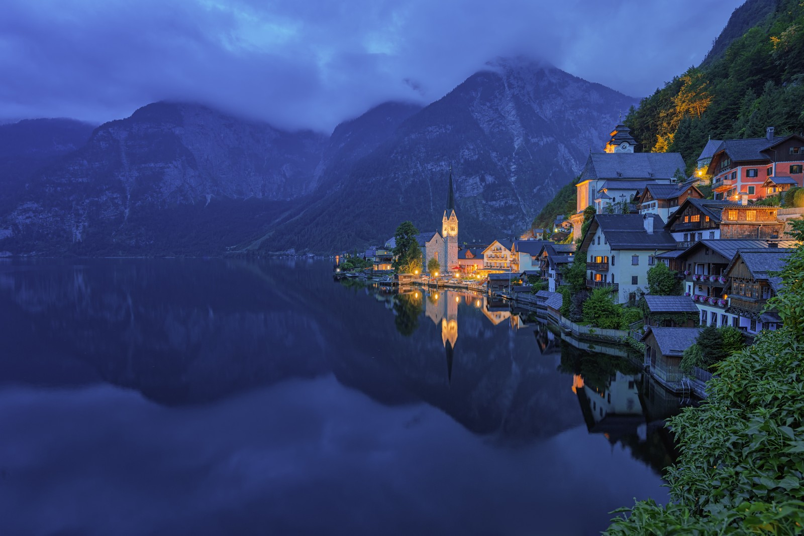 Una vista árabe de una ciudad en un lago con montañas de fondo (montañas, pueblo, iglesia, noche, frío)