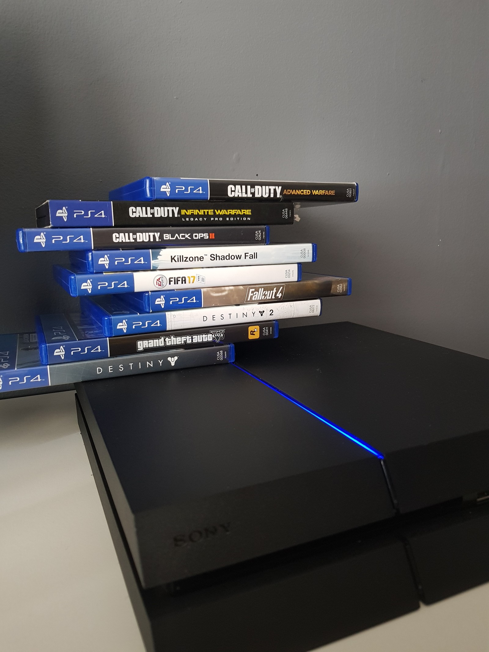 Un primer plano de una pila de juegos de playstation 4 en una mesa (gaming, ps4)