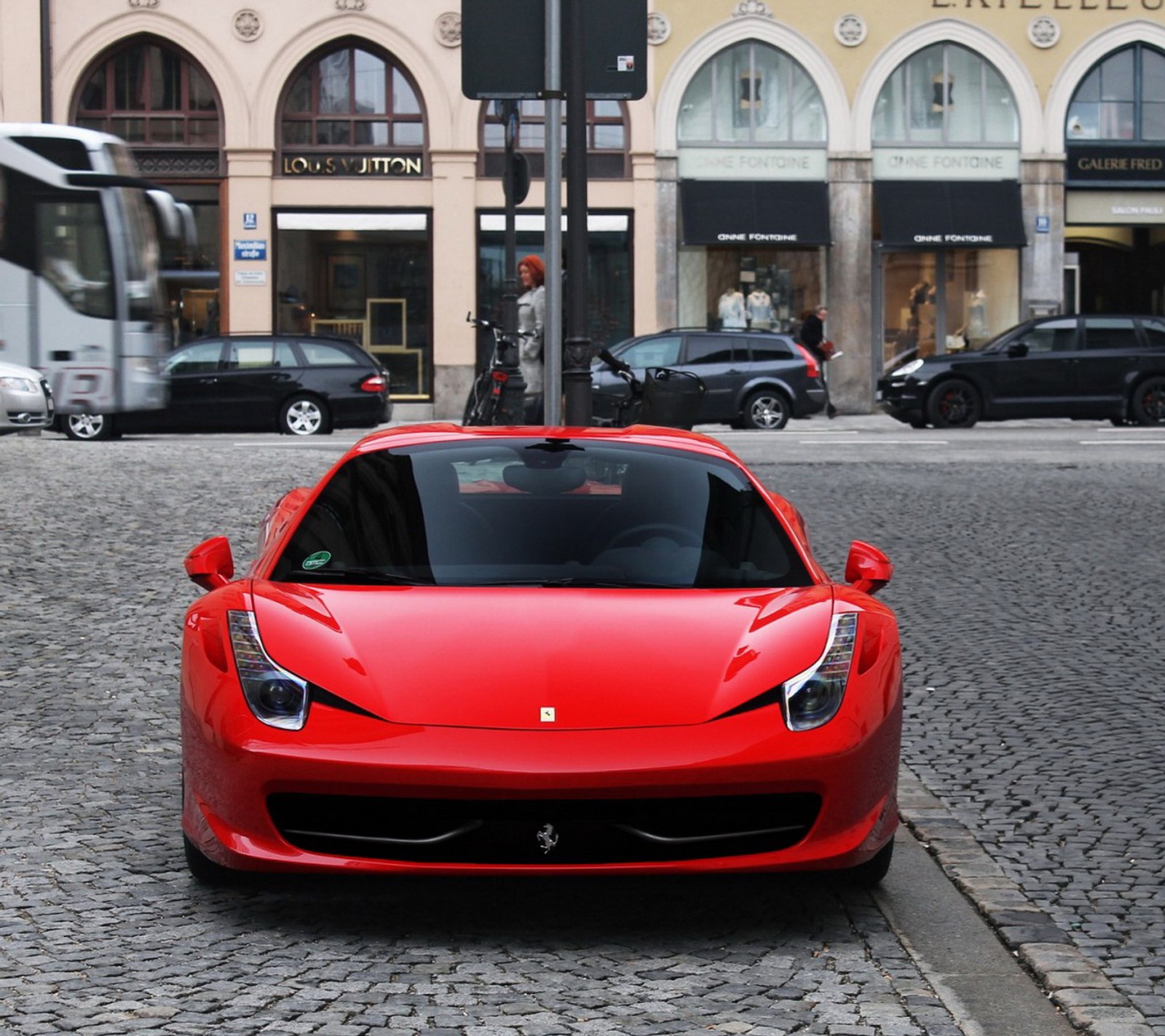 Imagen de un coche deportivo rojo estacionado en una calle de adoquines (coche)