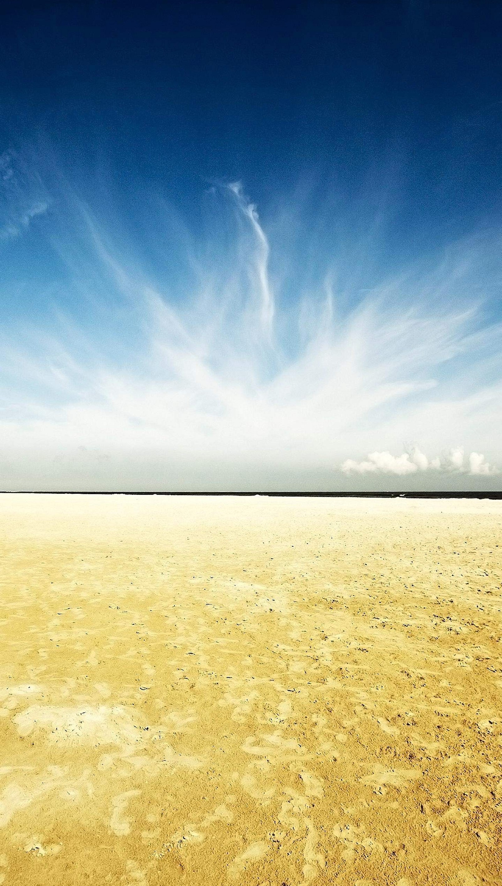 There is a lone kite flying in the sky over a sandy beach (beach, nature, sand, sky)