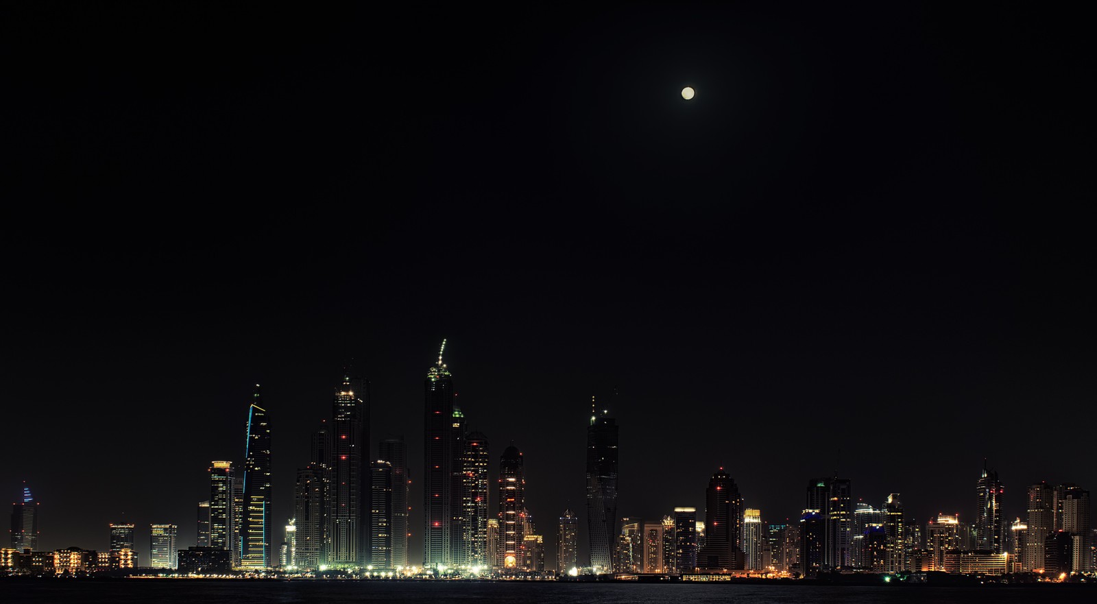 Une vue d'une ville la nuit avec une pleine lune (paysage urbain, nuit, gratte ciel, horizon, panorama)