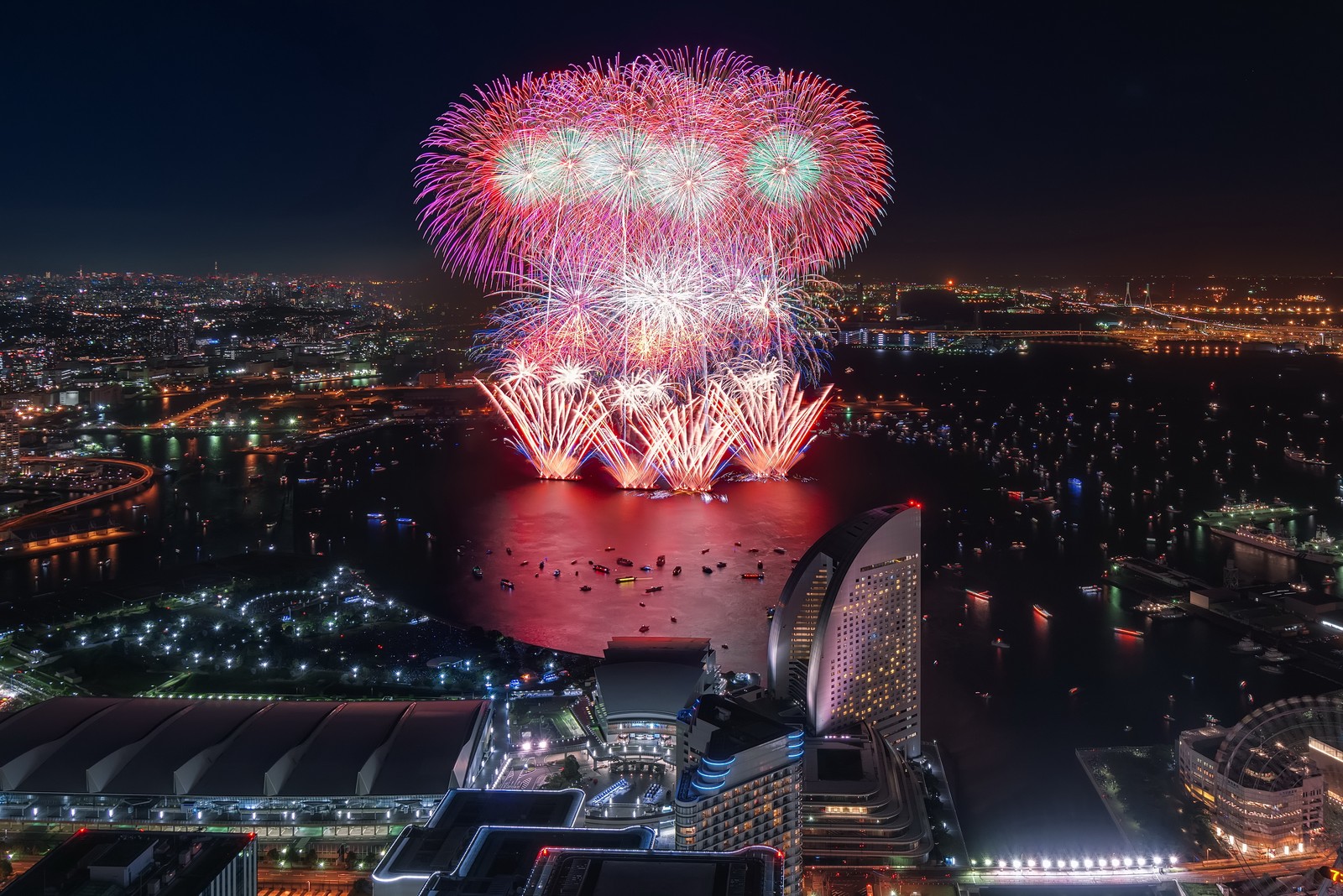 Los fuegos artificiales iluminan el cielo sobre una ciudad por la noche (yokohama landmark tower, torre eiffel, fuegos artificiales, torre, hito)