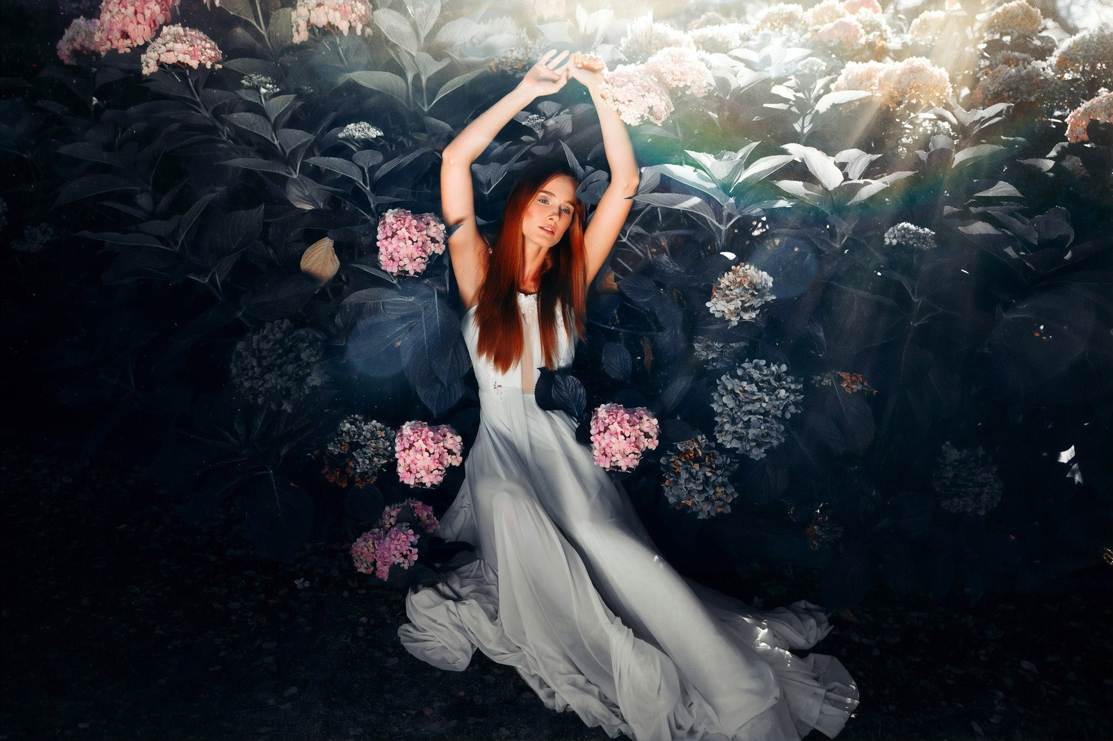 Una mujer con un vestido blanco de pie frente a un arbusto de flores (belleza, rosa, vestido, moda, reflexión)