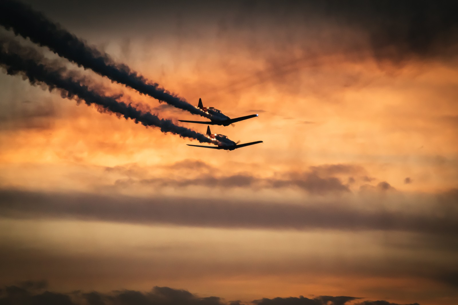 Há dois aviões voando no céu com fumaça saindo deles (aeronave, voo, por do sol, avião a jato, aviação)