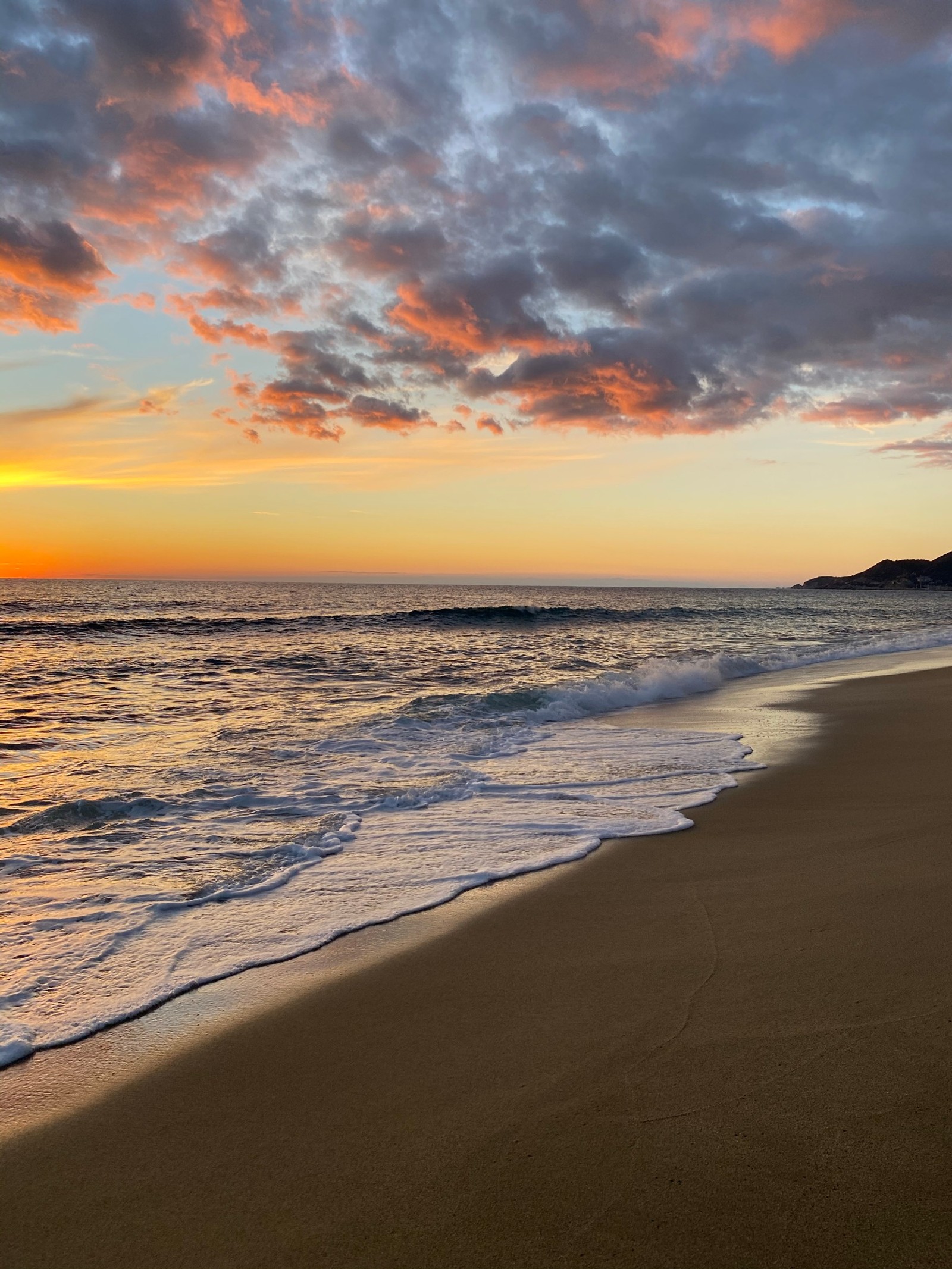 Coucher de soleil sur la plage avec une seule planche de surf au premier plan (océan, mer, eau, nuage, ressources en eau)