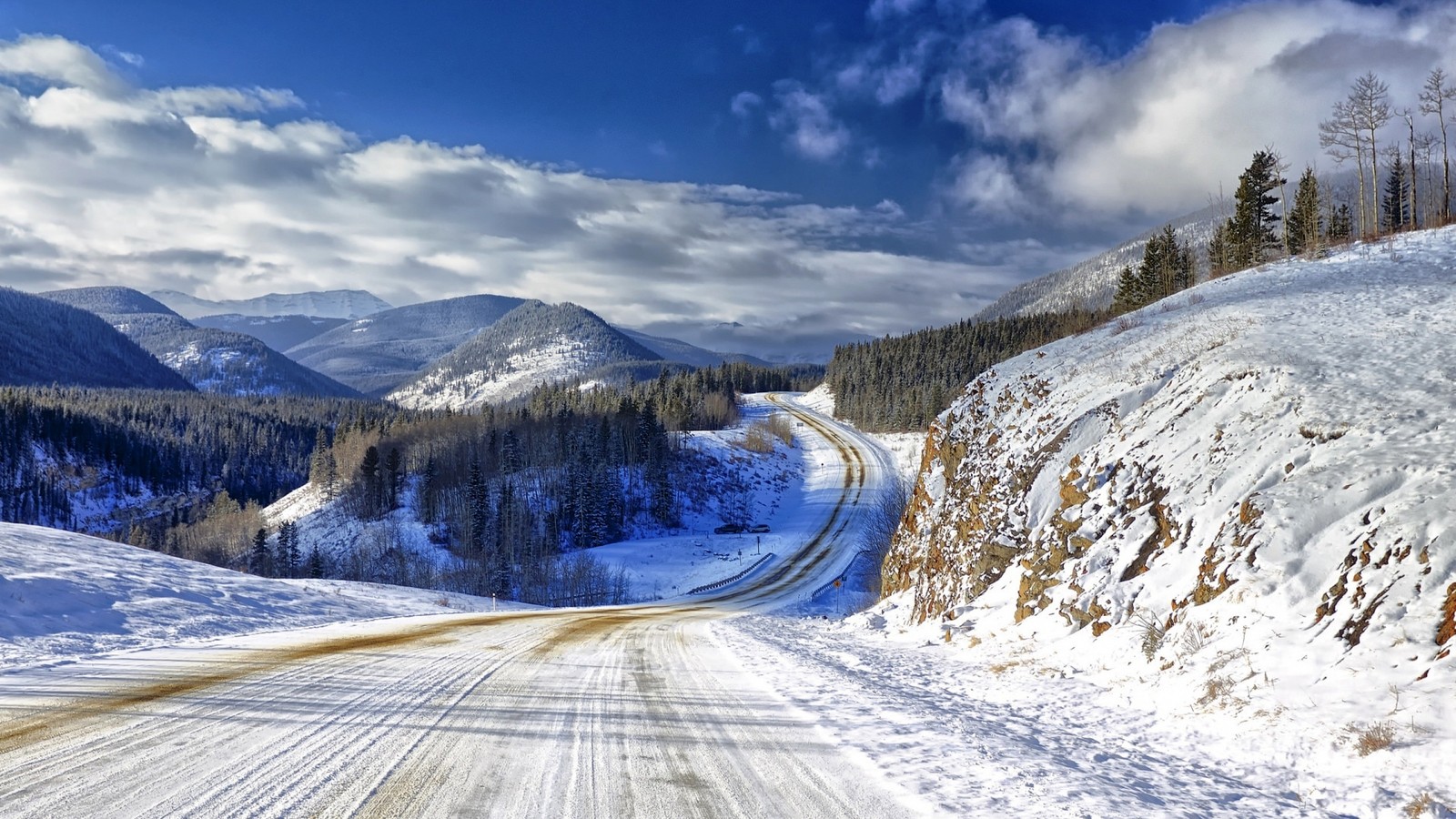 Blick auf eine verschneite straße mit einem berg im hintergrund (winter, schnee, berg, gebirgige landformen, gebirgspass)