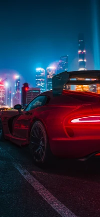 Red Sports Car with Vibrant Cityscape Backdrop