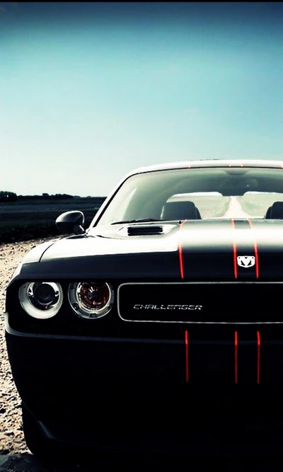 Dodge Challenger negro con rayas rojas contra un cielo despejado