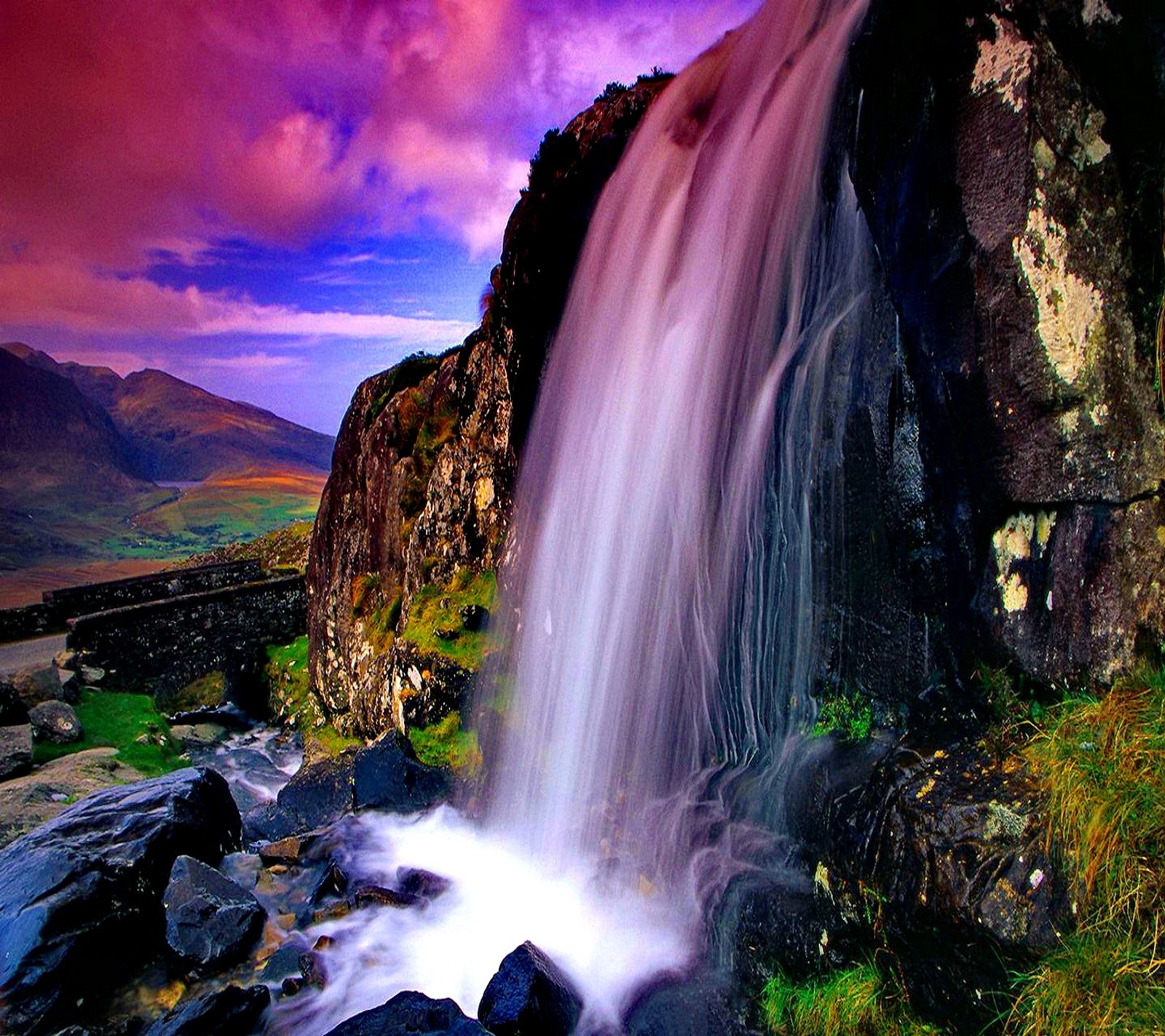 Cachoeira arafed no meio de uma montanha rochosa com um céu roxo (colorido, cachoeira)