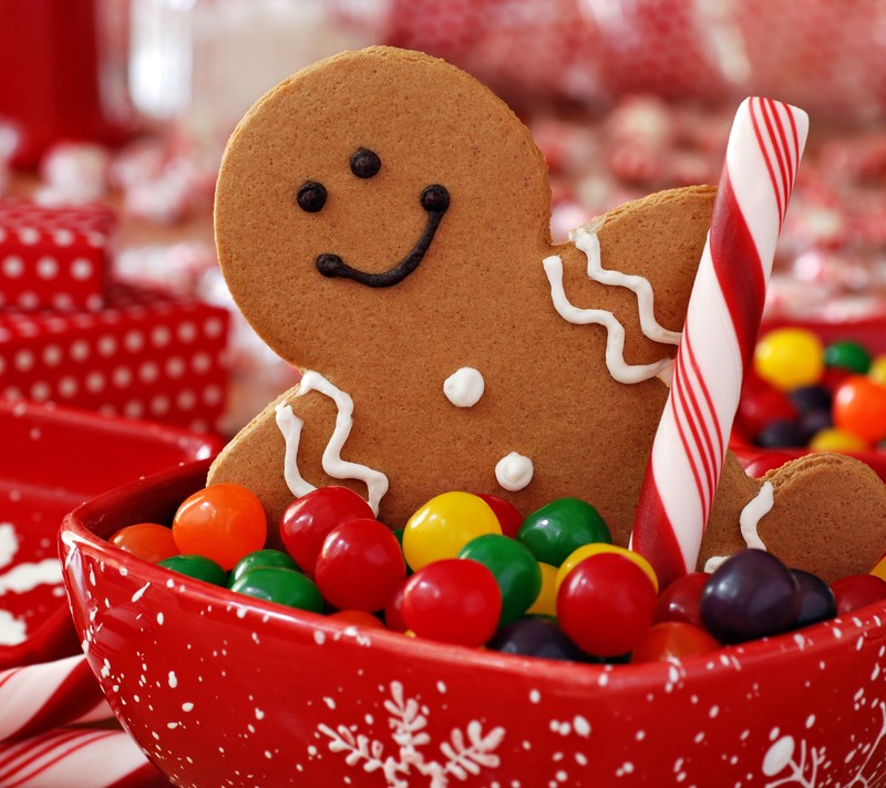 Ein lebkuchenmann liegt in einer schüssel mit süßigkeiten. (weihnachtsplätzchen, bunt, frohe weihnachten, weihnachten)