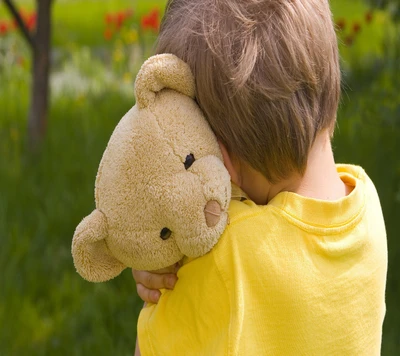 Seul avec des souvenirs : Un garçon triste et son ours en peluche