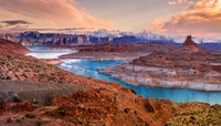 Impresionante paisaje de cañón al amanecer, que muestra los vibrantes matices del Lago Powell y las formaciones escarpadas de las tierras baldías circundantes.