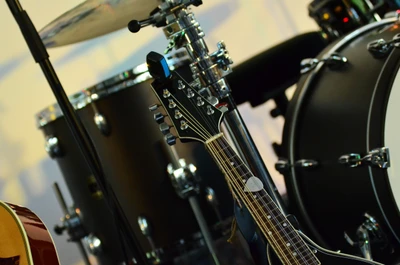 Close-up de uma bandolim posicionado ao lado de um conjunto de bateria, mostrando uma mistura de instrumentos de corda e percussão.