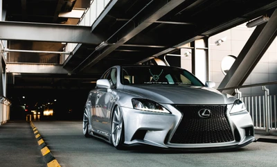 Lexus IS modificado com kit de carroceria elegante e rodas personalizadas, exibindo uma postura esportiva em um ambiente urbano.