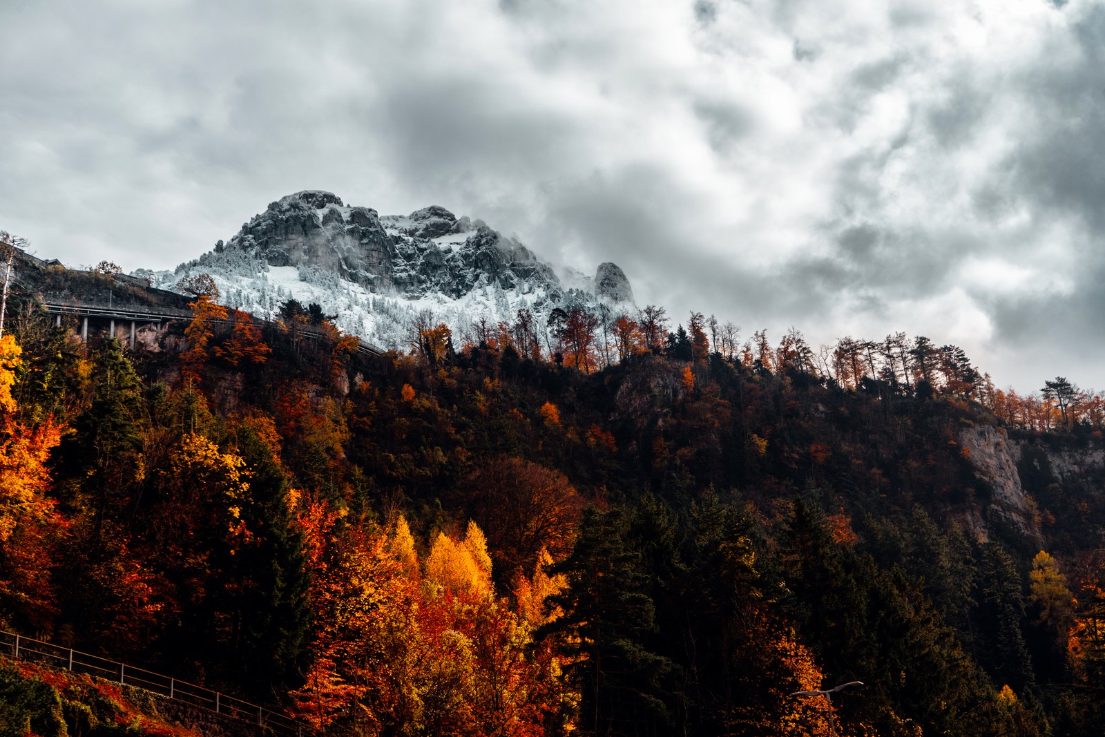 A view of a mountain with a snow covered mountain in the background (alps, autumn, alps mountains, forest, wilderness)