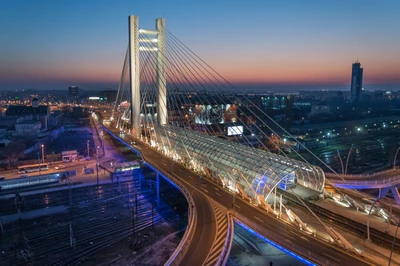 Illuminated Cable-Stayed Bridge at Dusk Over Urban Skyline