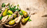 Poires fraîches dans un panier rustique avec des feuilles vertes