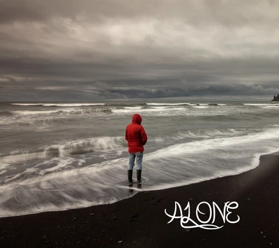 Una figura solitaria con una chaqueta roja se encuentra al borde de un mar tempestuoso, encarnando una sensación de soledad contra un cielo dramático.