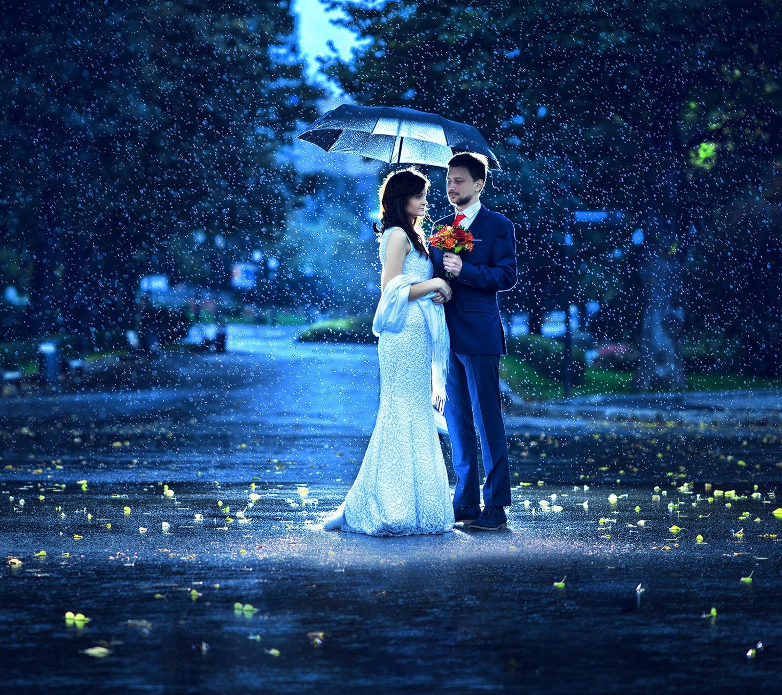 Bride and groom standing in the rain with umbrellas (couple in rain, love, rain)