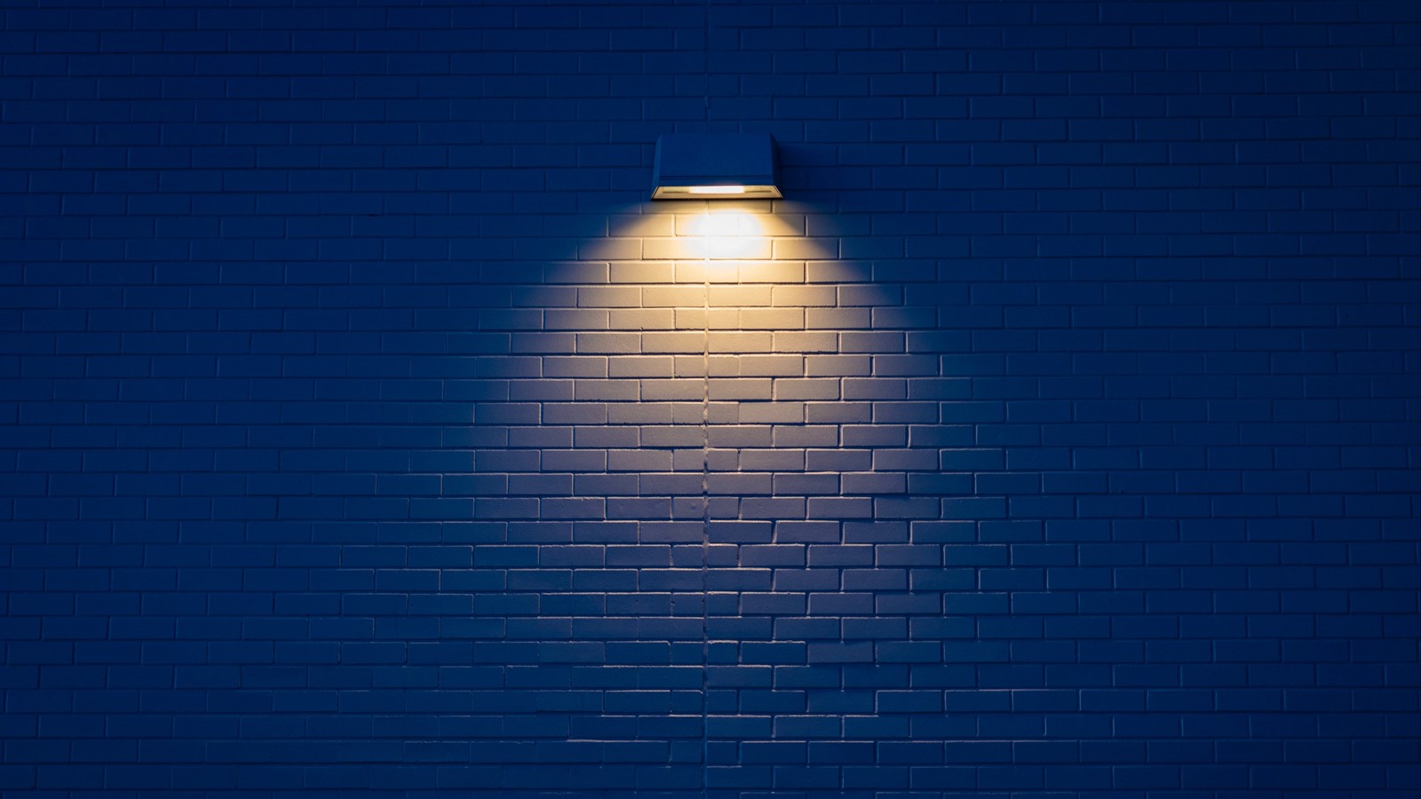 Imagen redondeada de una pared con una luz y un hidrante na frente (azul, ligero, noche, brillo)