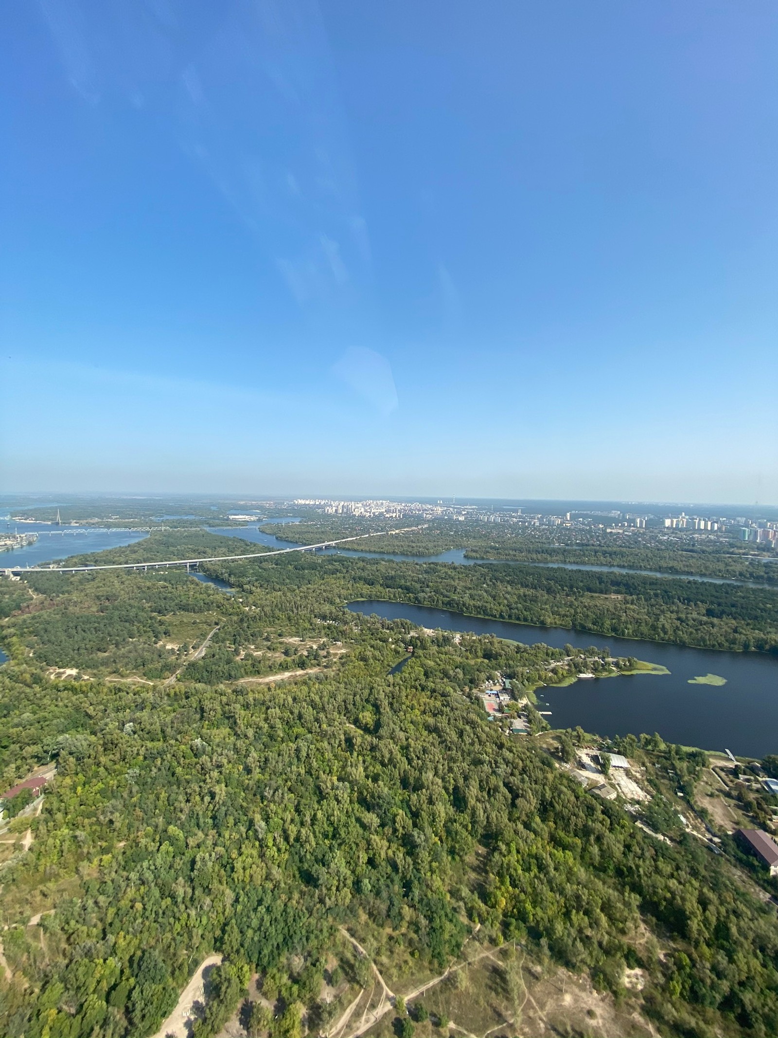 Vista aérea de um rio e uma cidade de um avião (vista aérea, planície, horizonte, canal, pântano)