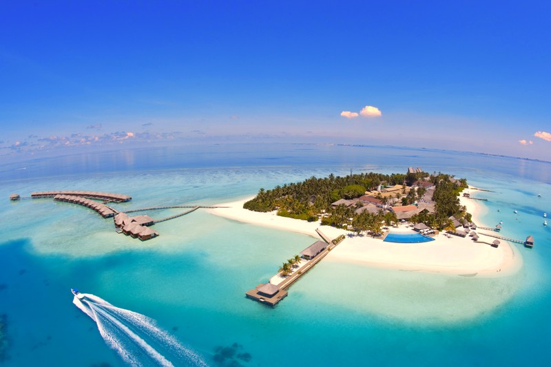 Вид на маленький остров с лодкой в воде (велассару мальдивы, velassaru maldives, остров, курорт, пляж)