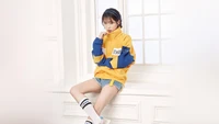 IU en un atuendo deportivo elegante junto a la ventana