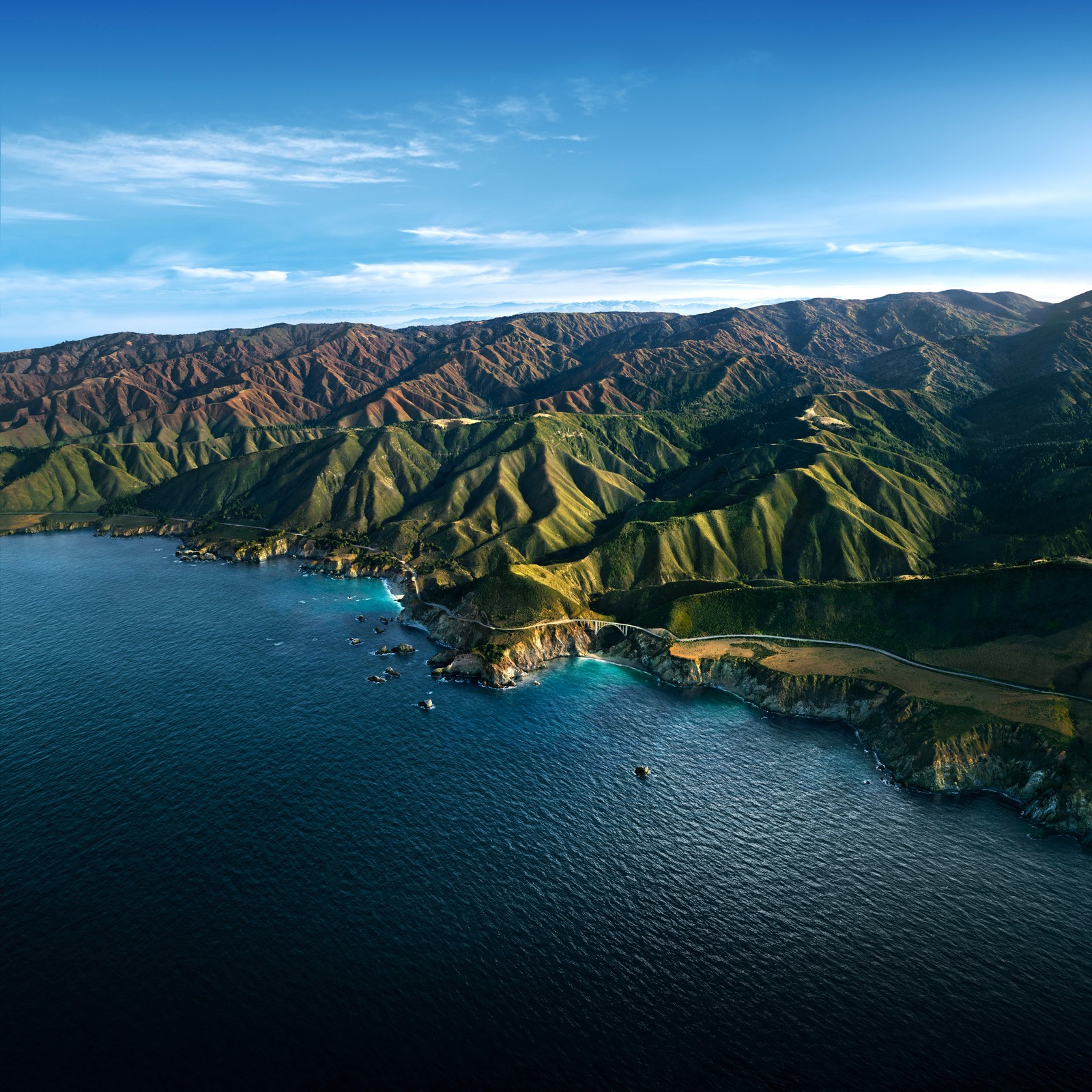 Une vue d'un grand plan d'eau près d'une chaîne de montagnes (big sur, montagnes, lumière du jour, ciel bleu, macos big sur)