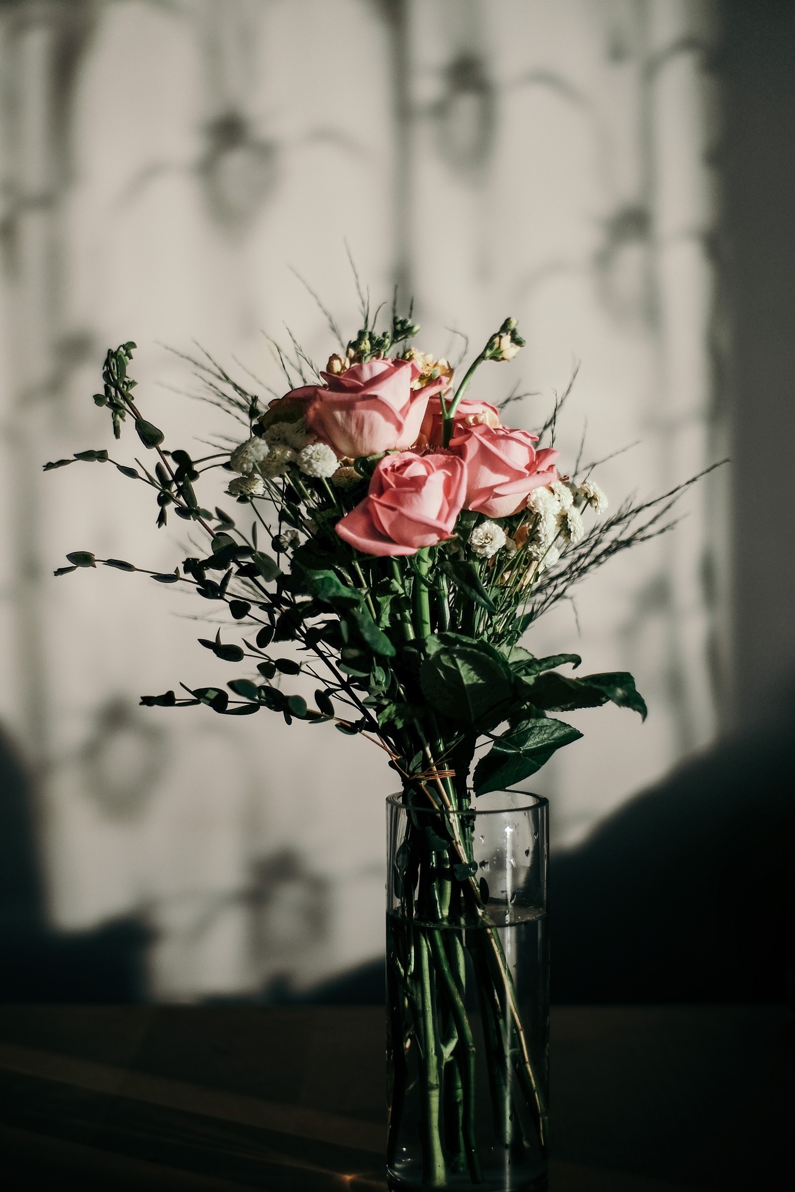 Hay un jarrón con flores en una mesa (diseño floral, flor, arreglo floral, ramo de flores, flores rosas)