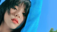 Chaeyoung de TWICE, montrant son regard captivant contre un ciel bleu éclatant.