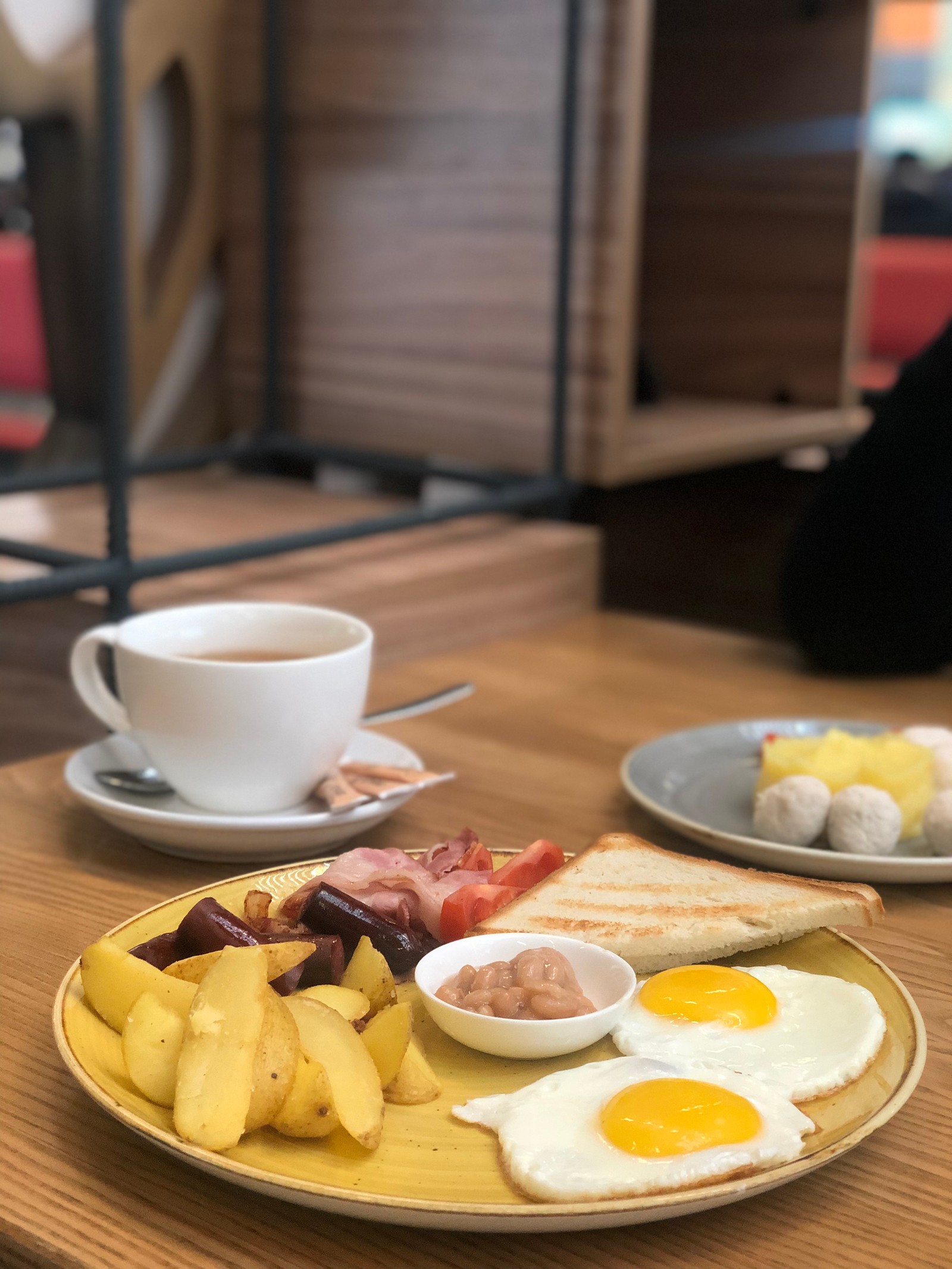 Hay un plato de comida en una mesa con una taza de café (comida, desayuno, desayuno completo, utensilios de servir, taza de café)