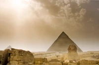 The Great Sphinx of Giza with the Great Pyramid in the background under a dramatic sky, showcasing Egypt's ancient history and monumental architecture.