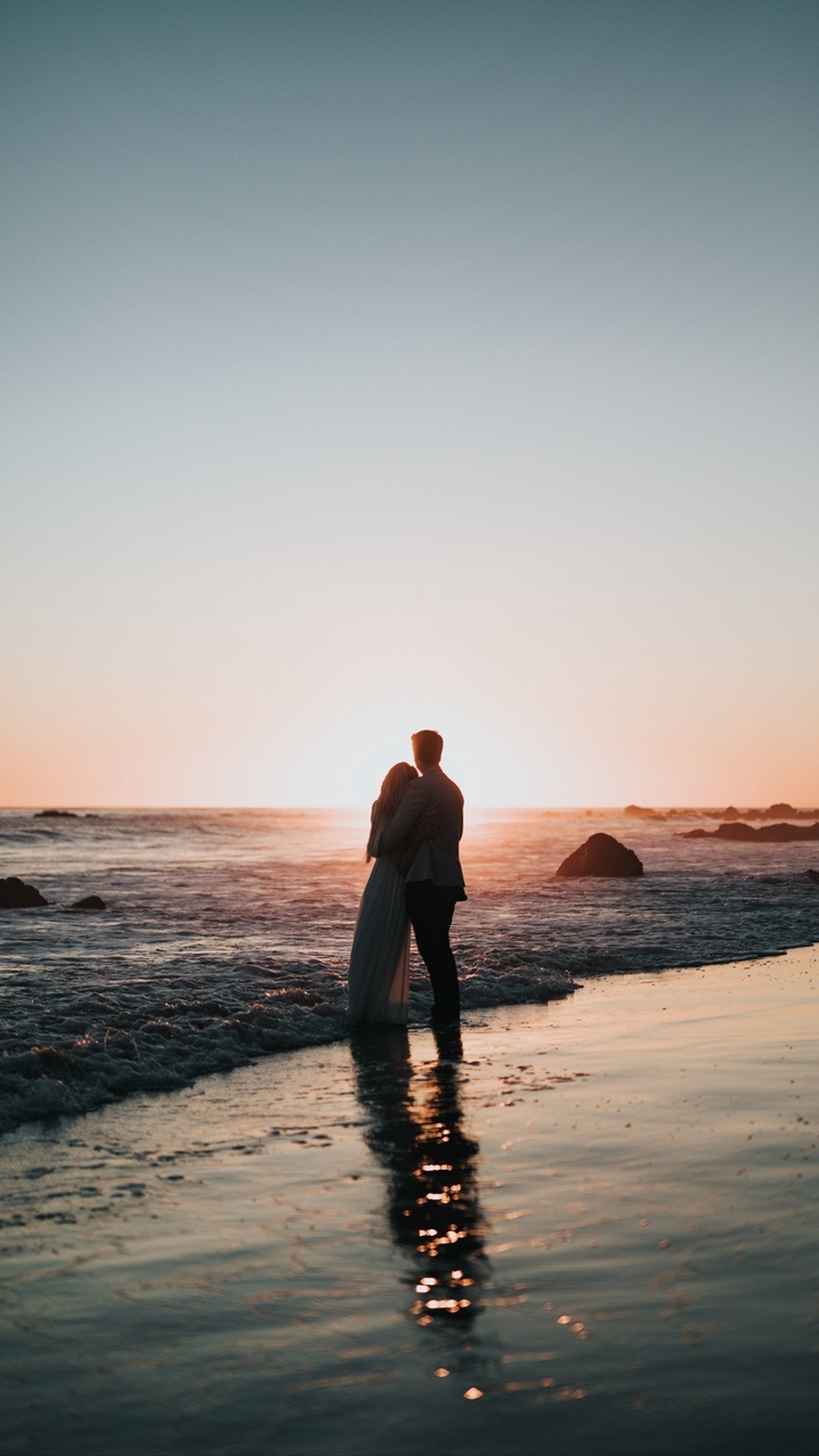 There is a man and woman standing on the beach at sunset (couples, love, cute, romantic, beach)