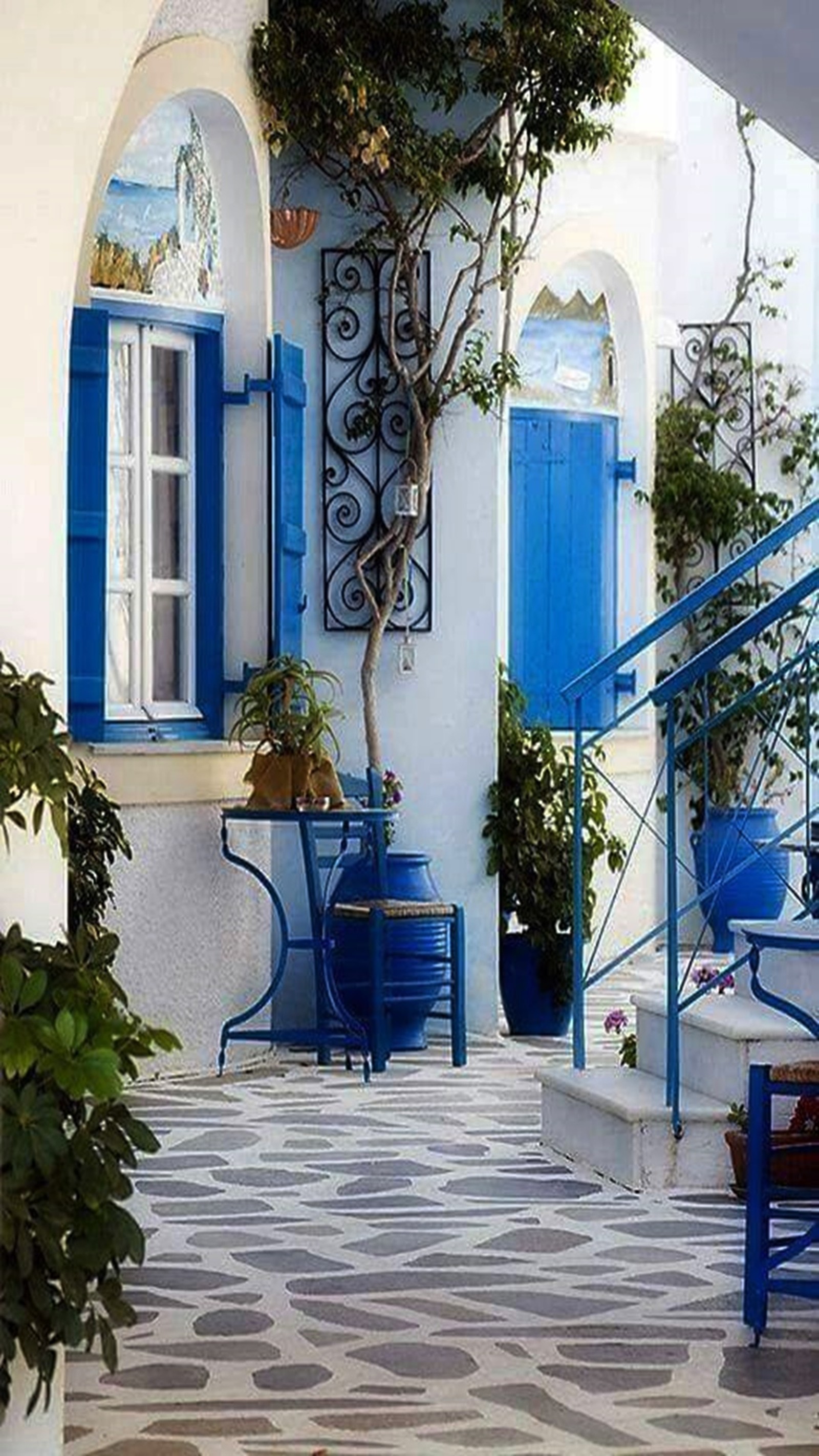 Hay un edificio azul y blanco con una puerta azul y un banco azul (casa, paraíso)