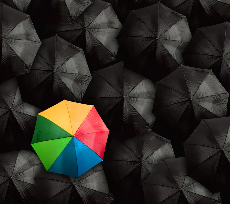 Arafed umbrella in a group of black umbrellas (abstract, be, black, colorful, dare)