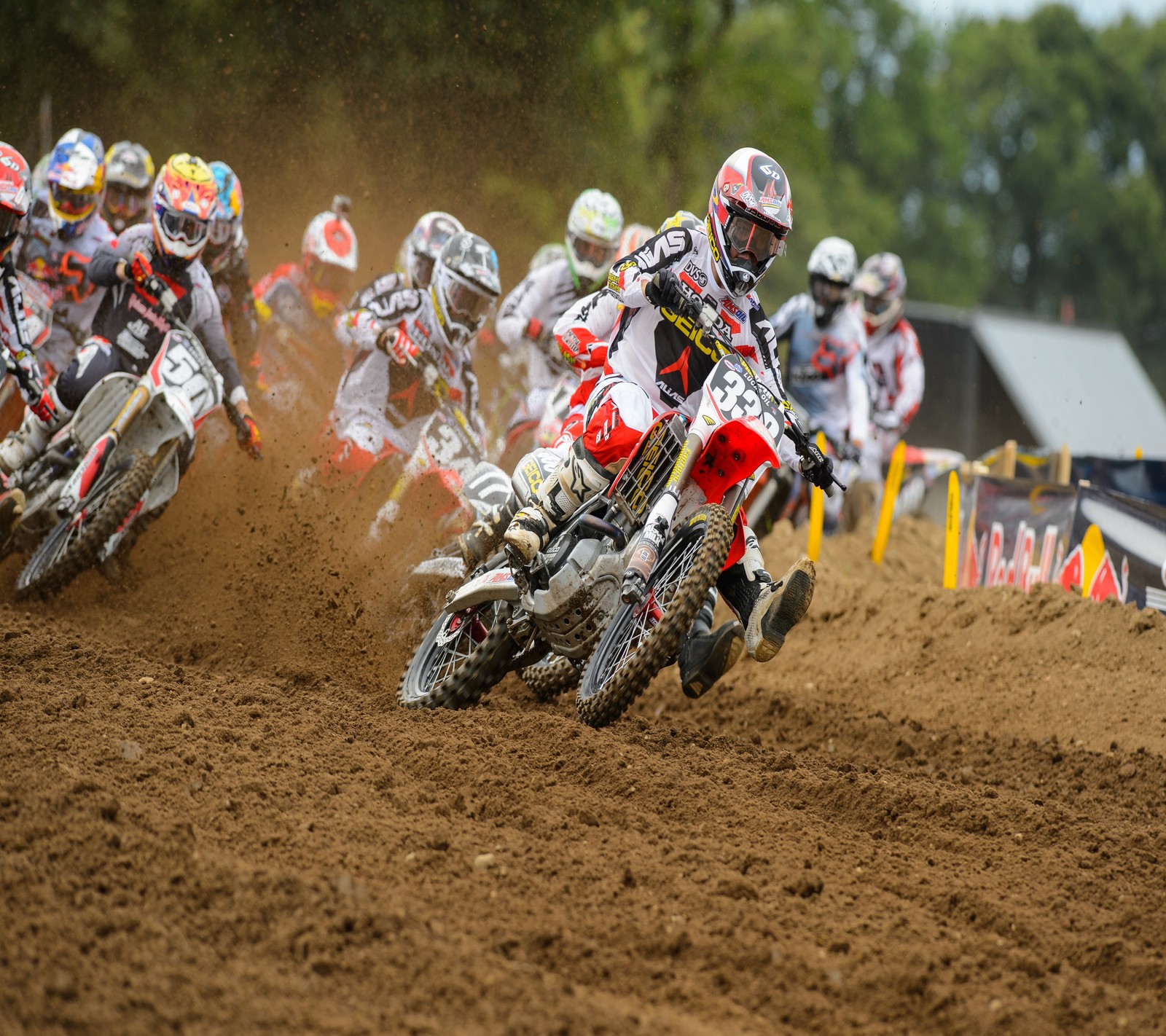 Plusieurs personnes sur des motos tout-terrain courant sur une piste de terre (vélo, motocross, race)