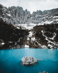 Lago glacial sereno cercado por majestosa cadeia de montanhas