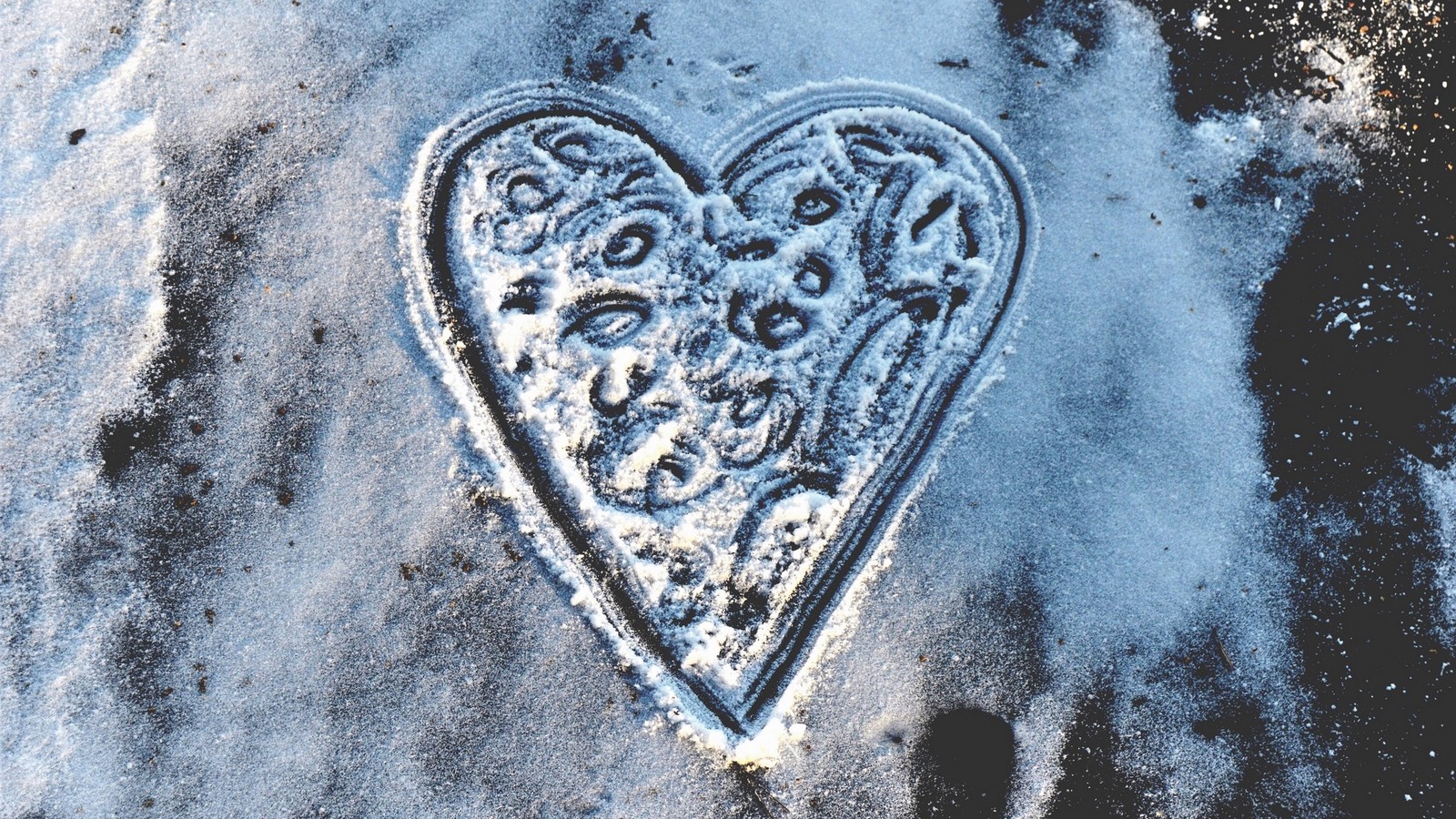 Un gros plan d'un objet en forme de cœur sur une surface enneigée (cœur, amour, hiver, neige, givre)