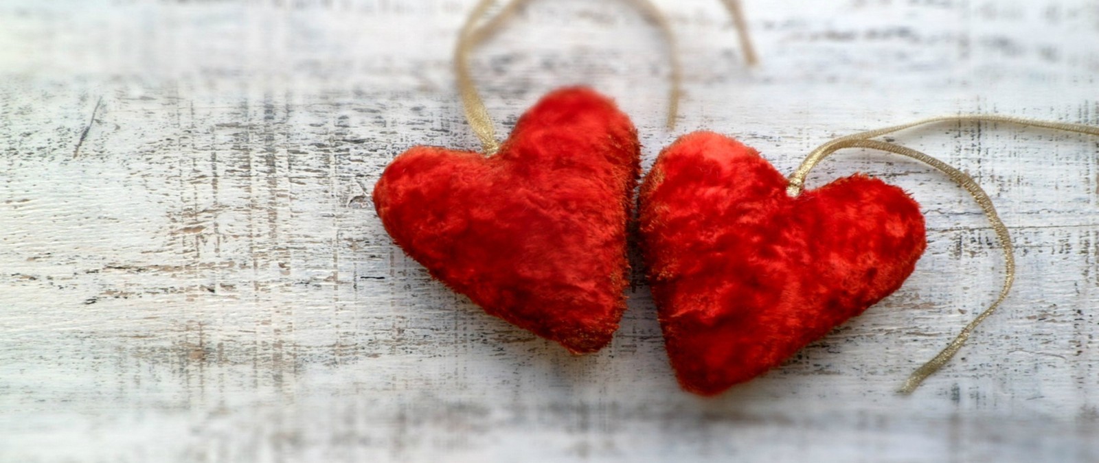 Hay dos corazones rojos colgando de un hilo en una mesa (corazón, rojo, amor, facebook, romance)