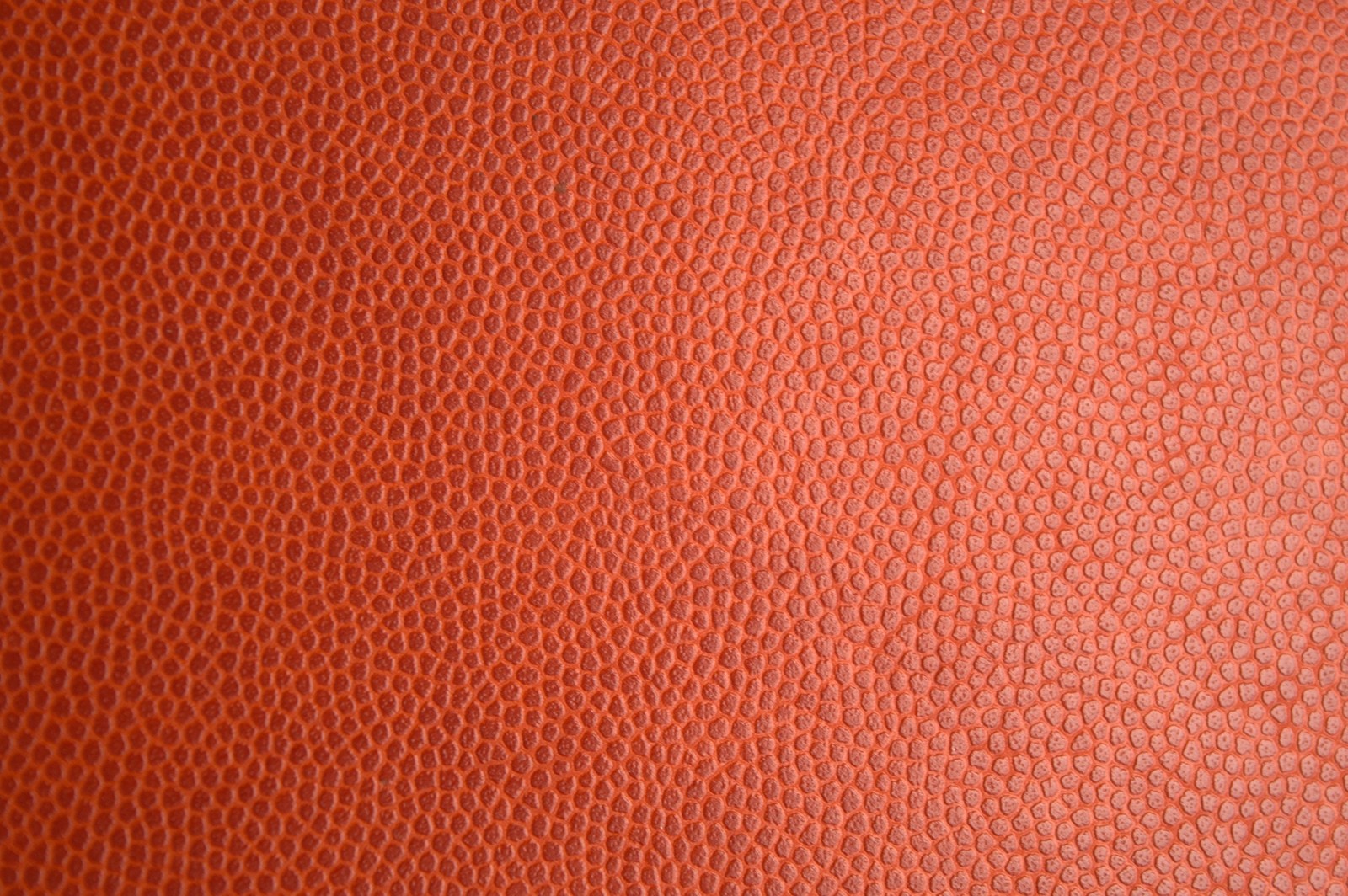 A close up of a leather surface with a pattern (leather, textile, orange, pattern, peach)