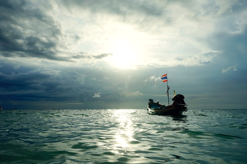 Лодка плавает в воде под облачным небом (море, вода, океан, горизонт, лодка)